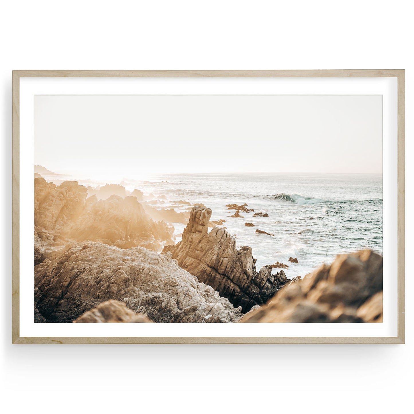 Framed coastal sunset print featuring rugged beige shoreline, boho beach rocks, and soft neutral tones — fine art wall decor for calming interiors.