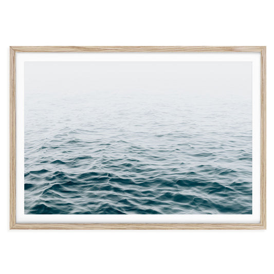 Minimalist ocean wave print featuring blue water movement and soft sea foam under natural light, modern coastal wall art for beach house or nautical decor.