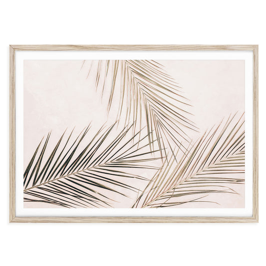 Minimalist tropical palm leaves wall art in pale pink tones, horizontal fine art print for bedroom or living room, nature-inspired neutral home decor.
