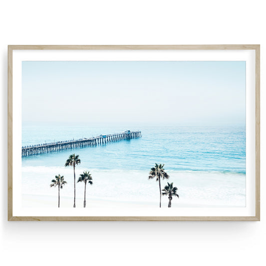 Coastal wall art featuring San Clemente Pier, soft blue ocean tones, and palm trees — California beach photography for serene interiors.

