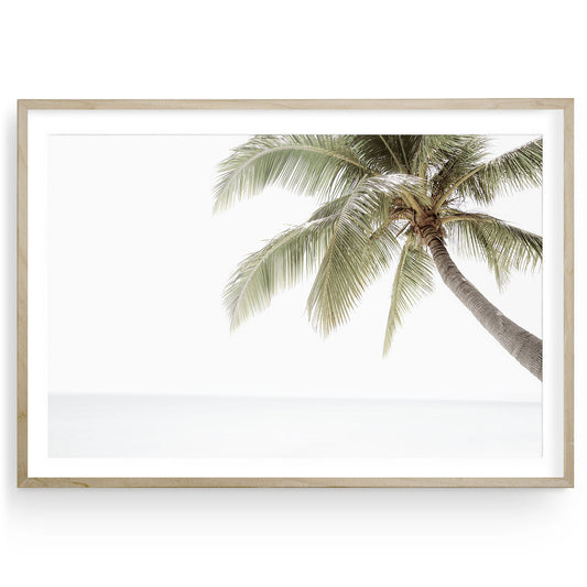 Minimalist palm tree wall art with neutral tones and soft tropical beach sky, modern coastal fine art print available framed or unframed.