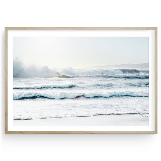 Crashing ocean waves with white seafoam on the shore of Santa Monica beach under soft light, minimalist coastal wall art in calming blue and white tones